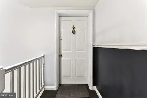 a view of a hallway with wooden floor and entryway