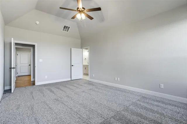 an empty room with ceiling fan and window