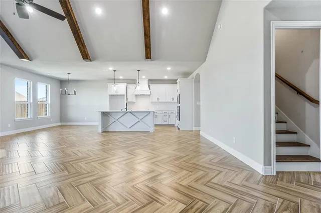 a view of a livingroom with wooden floor and stairs