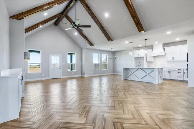 a view of large kitchen with stainless steel appliances kitchen island granite countertop a refrigerator and cabinets