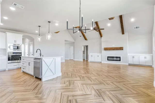 a kitchen with kitchen island a sink stainless steel appliances and cabinets
