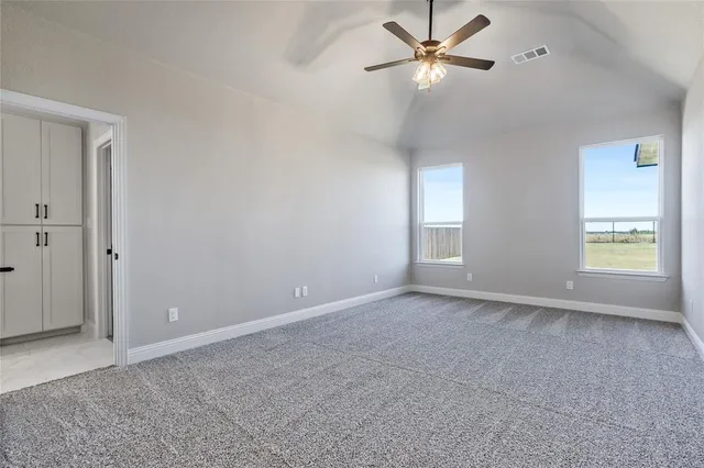 an empty room with closet and a ceiling fan