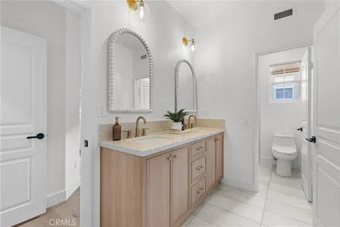 a bathroom with a double vanity sink and a toilet