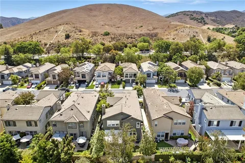 an aerial view of a city with lots of residential buildings and mountain view in back