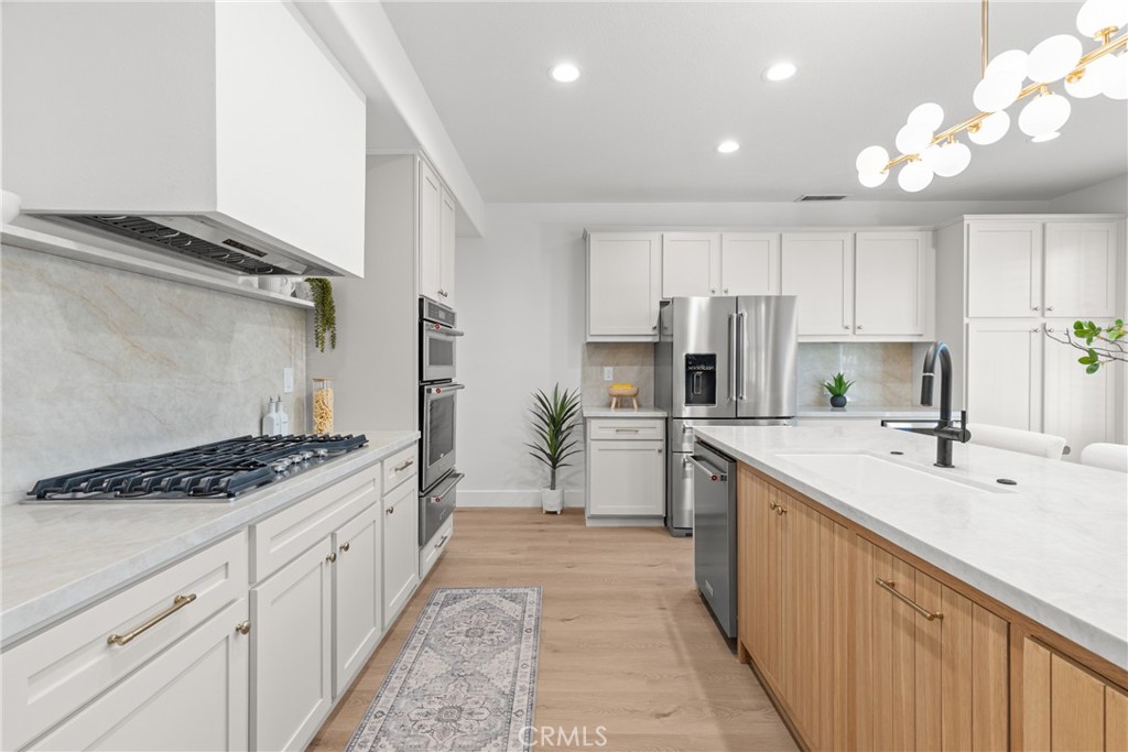 173 Parkside Drive Simi Valley, CA 93065 - Photo 6 of 31 a kitchen with white cabinets a sink stove and refrigerator