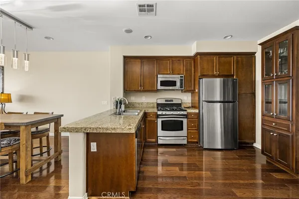 a kitchen with kitchen island granite countertop a refrigerator stove and microwave