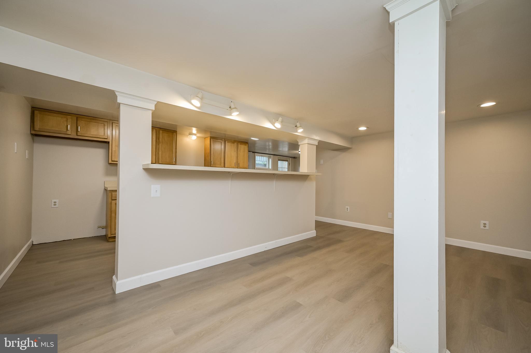 5 Lee Street Gaithersburg, MD 20877 - Photo 78 of 90 an empty room with wooden floor and a kitchen