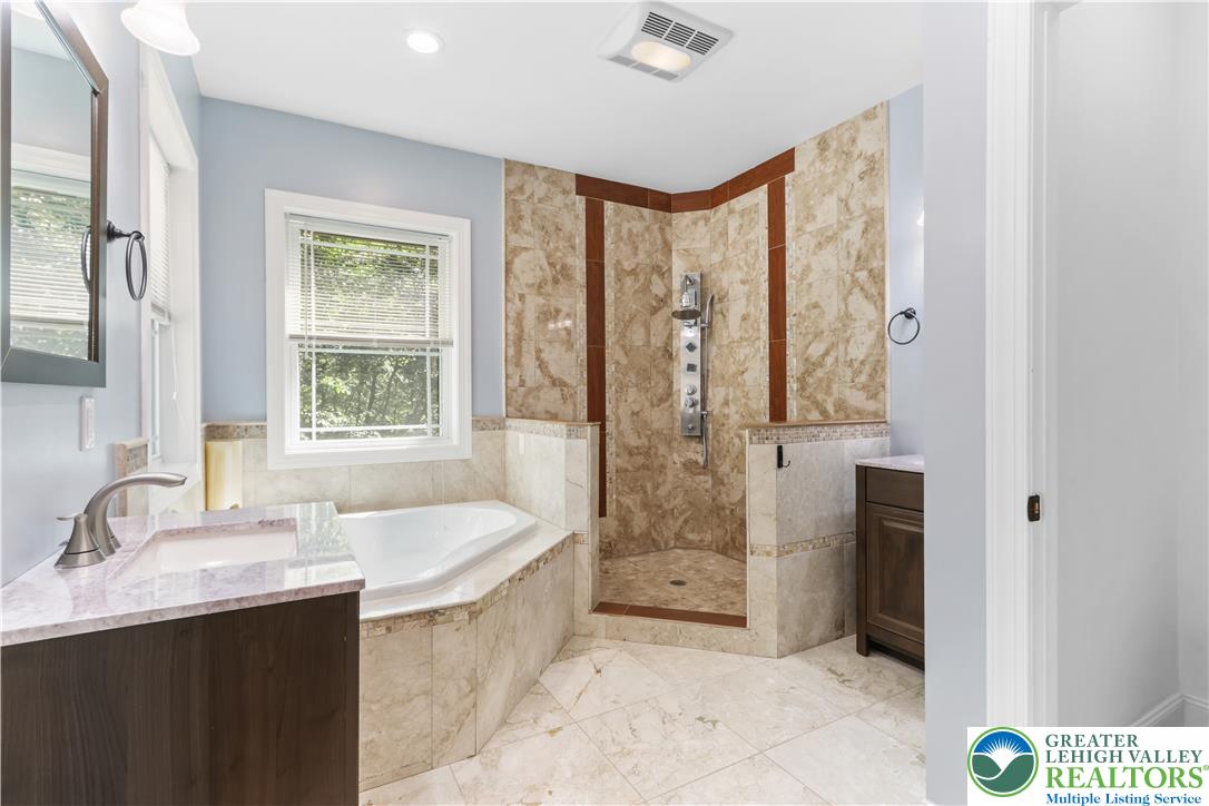 1007 Hampstead Road Bushkill, PA 18324 - Photo 22 of 72 Marble finishes throughout enhance this primary bathroom's spacious shower and inviting soaking tub.