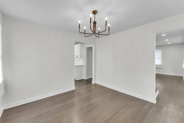 a view of a room with wooden floor and ceiling fan