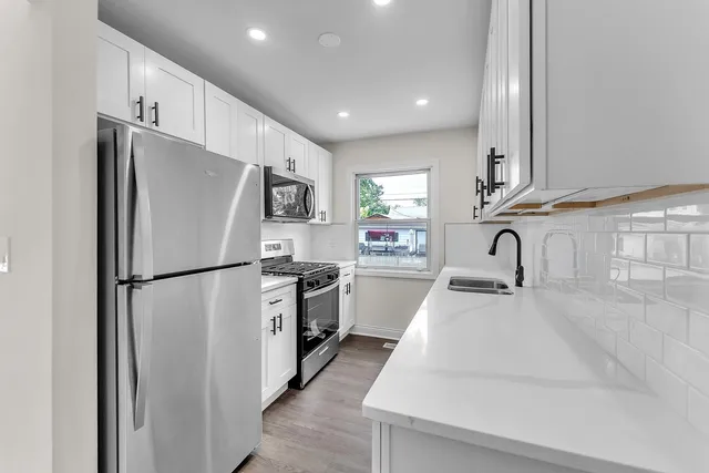 a kitchen with stainless steel appliances a refrigerator sink and stove