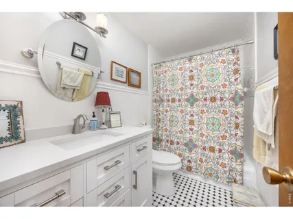 a bathroom with a sink toilet a mirror and shower curtain