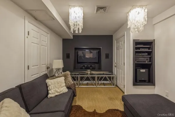 a living room with furniture a chandelier and a flat screen tv