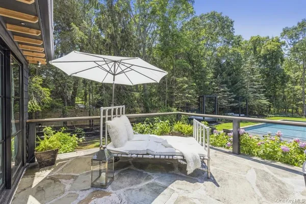 a view of a patio with a table chairs and a swimming pool