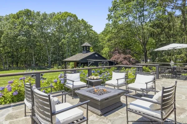 a patio with water view fountain and a fire pit