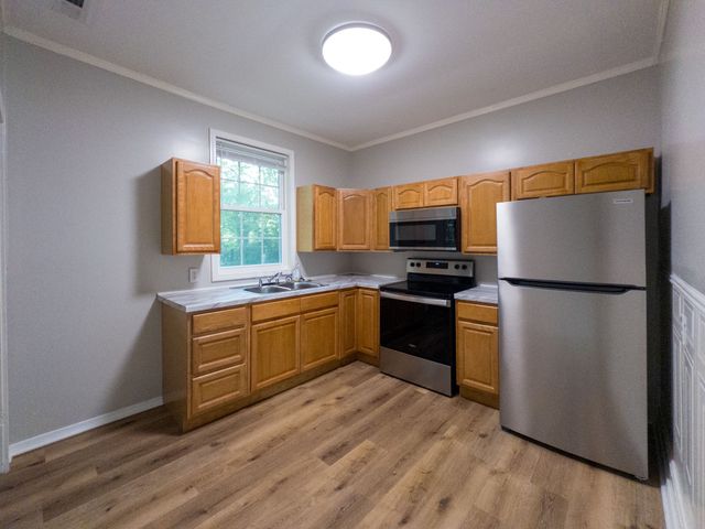a kitchen with granite countertop stainless steel appliances a refrigerator microwave and sink
