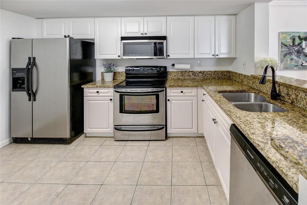 520 Southeast 5th Avenue, Unit 2605 Fort Lauderdale, FL 33301 - Photo 15 of 38 a kitchen with kitchen island granite countertop a stove a sink and a refrigerator