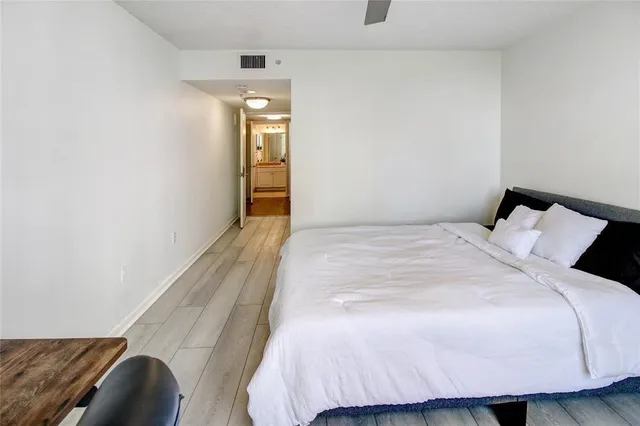 a bedroom with a bed and painting on the wall