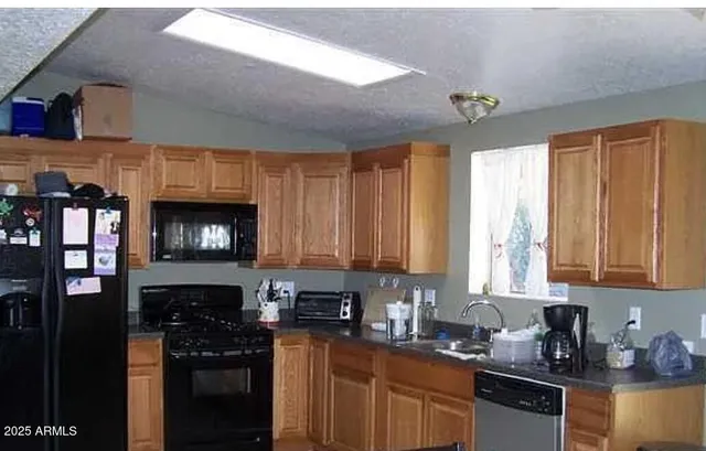 a kitchen with stainless steel appliances granite countertop a stove top oven a sink dishwasher and cabinets with wooden floor