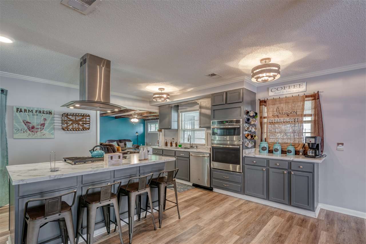 1631 Cranford Road Memphis, TN 38117 - Photo 7 of 21 a kitchen with stainless steel appliances a stove a sink dishwasher a dining table and chairs with wooden floor
