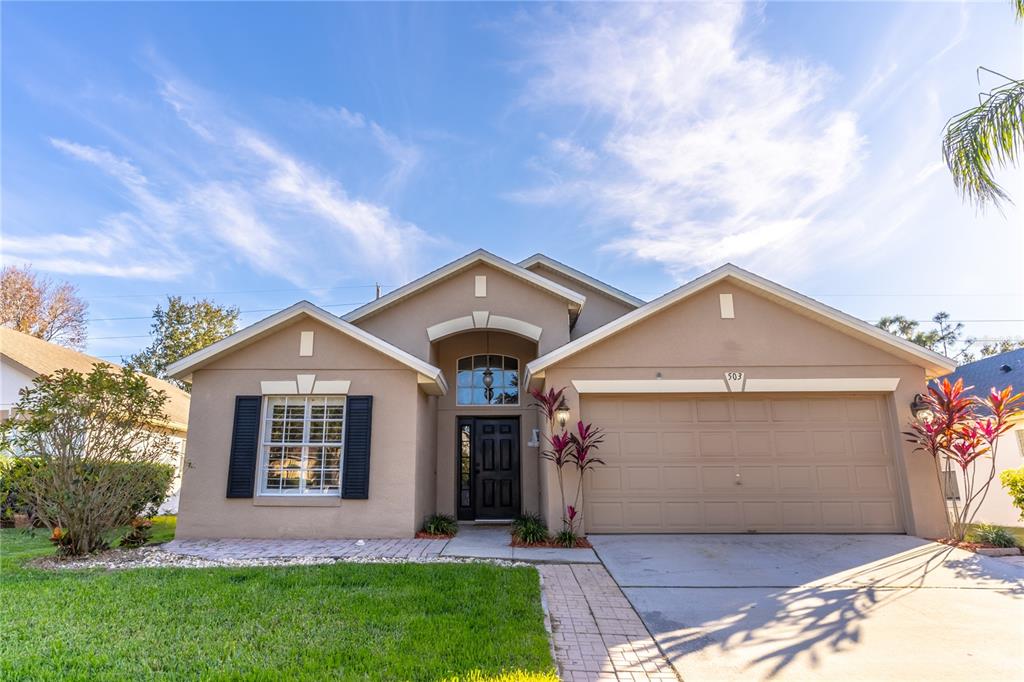 503 Mickleton Loop Ocoee, FL 34761 - Photo 1 of 1 a front view of a house with a garden and yard