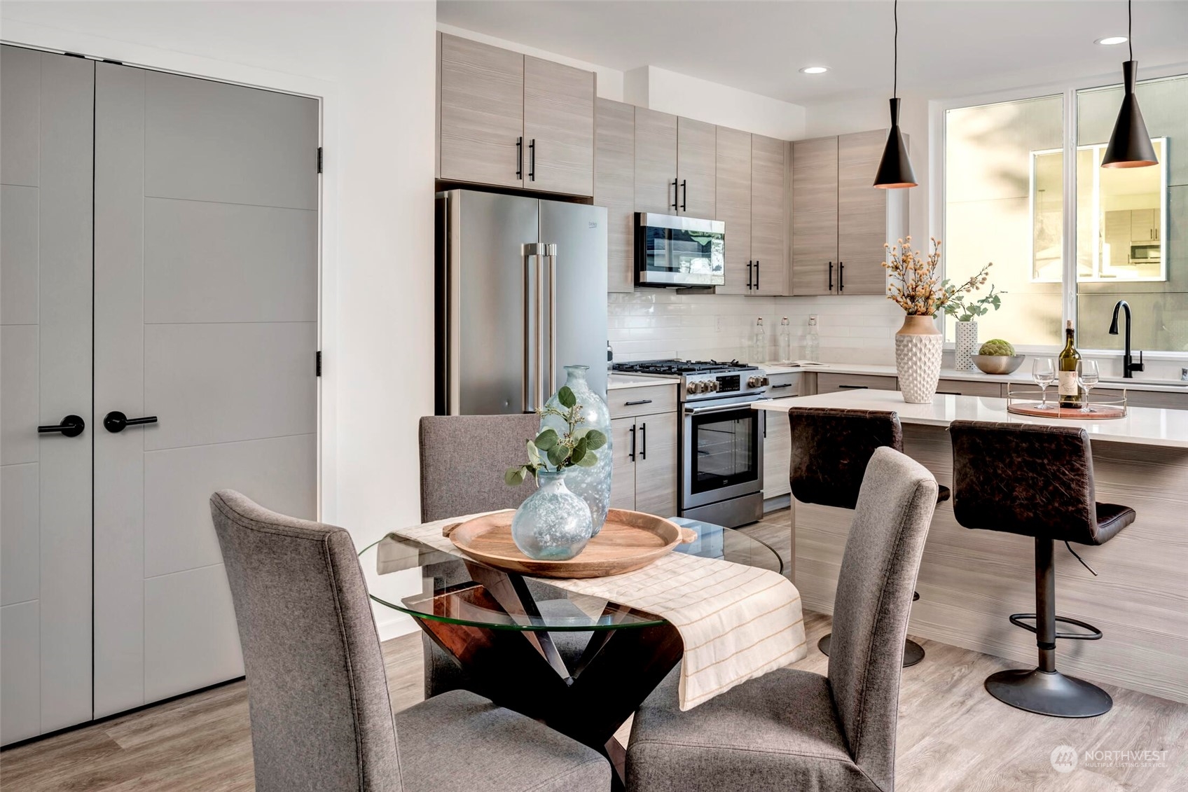 4024 Midvale Avenue North Seattle, WA 98103 - Photo 8 of 26 a kitchen with stainless steel appliances kitchen island granite countertop a dining table chairs and a refrigerator