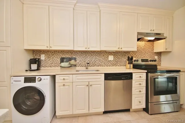 a kitchen with white cabinets and appliances