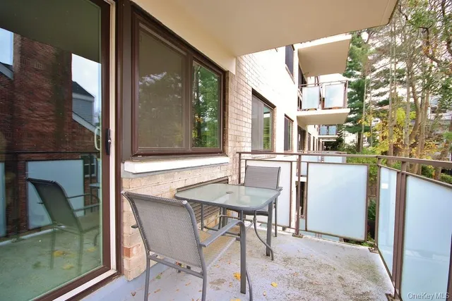 a view of a brick house with a chairs and table in front of a house