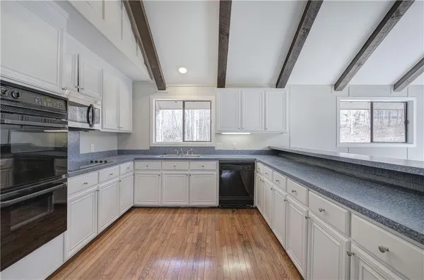 a view of a livingroom with wooden floor and a fireplace