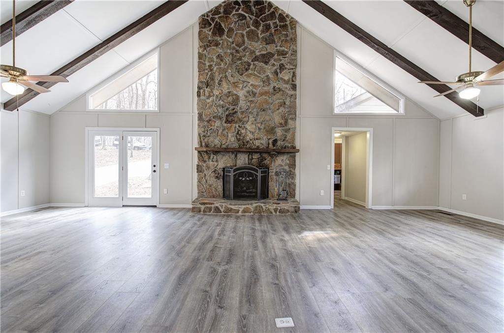 30 Tamarack Court Jasper, GA 30143 - Photo 6 of 70 an empty room with wooden floor fireplace and windows