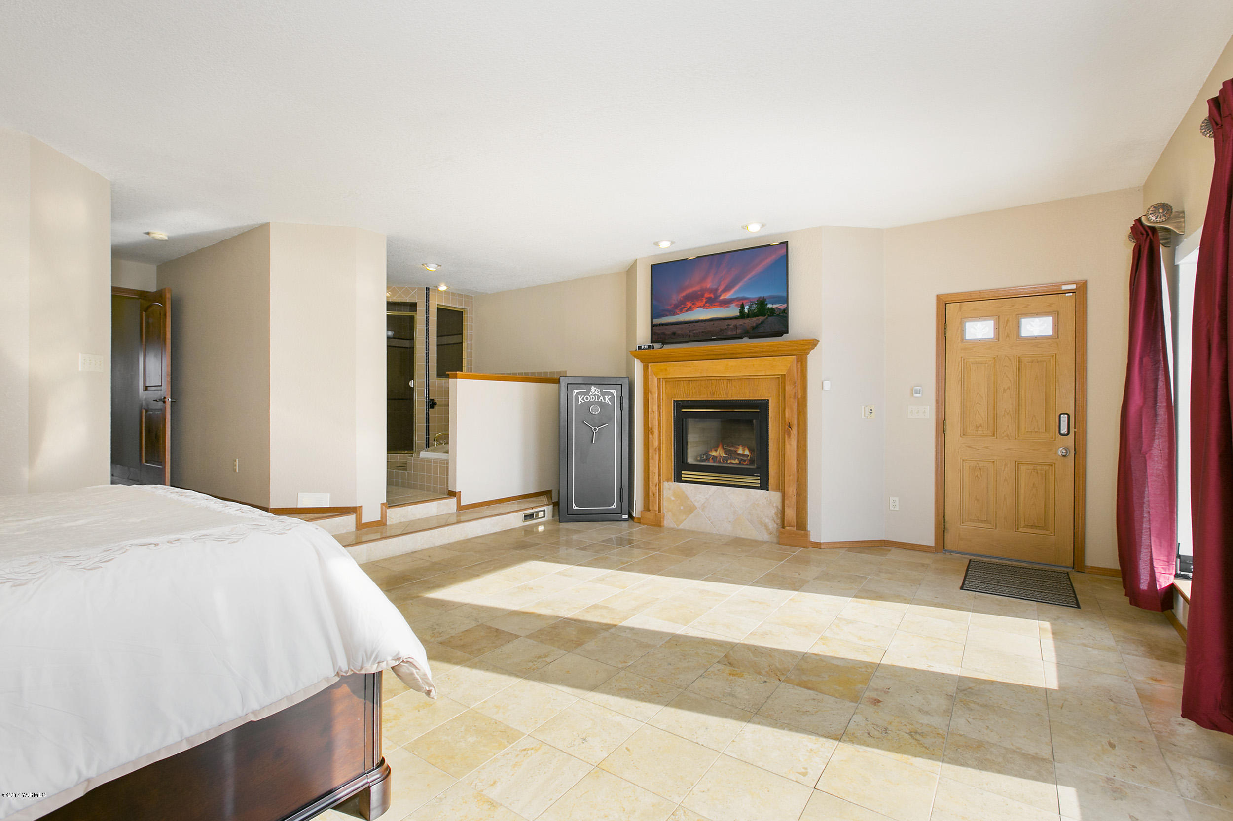 10709 Estes Road Yakima, WA 98908 - Photo 14 of 40 a spacious bedroom with a bed and a fireplace