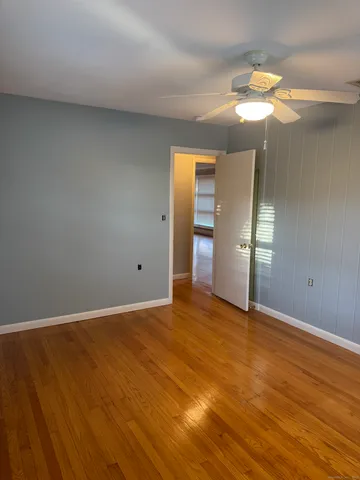 an empty room with wooden floor and mirror
