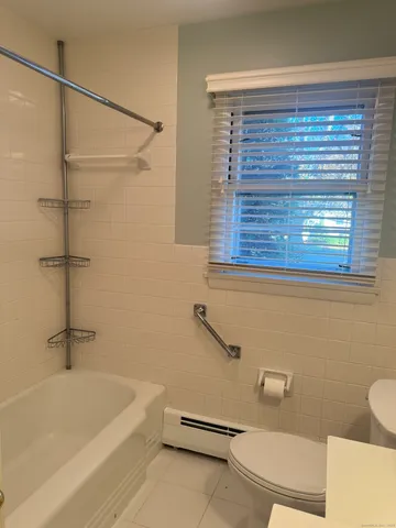 a bathroom with a tub a toilet and a shower