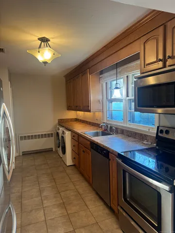 a kitchen with stainless steel appliances granite countertop a sink a stove a microwave and cabinets