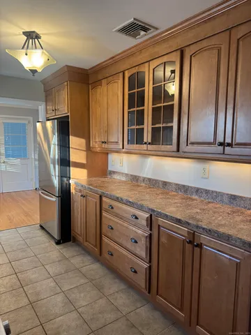 a kitchen with granite countertop a stove a sink and a refrigerator