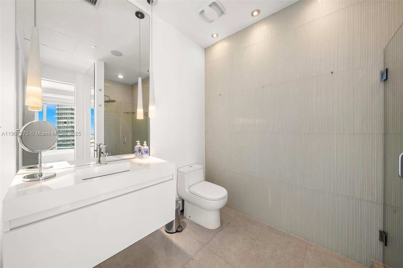 450 Alton Road, Unit PH4104 Miami Beach, FL 33139 - Photo 42 of 84 a bathroom with a sink a toilet and a mirror