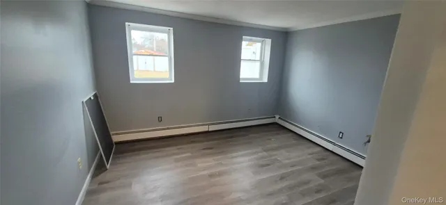 an empty room with wooden floor and mirror