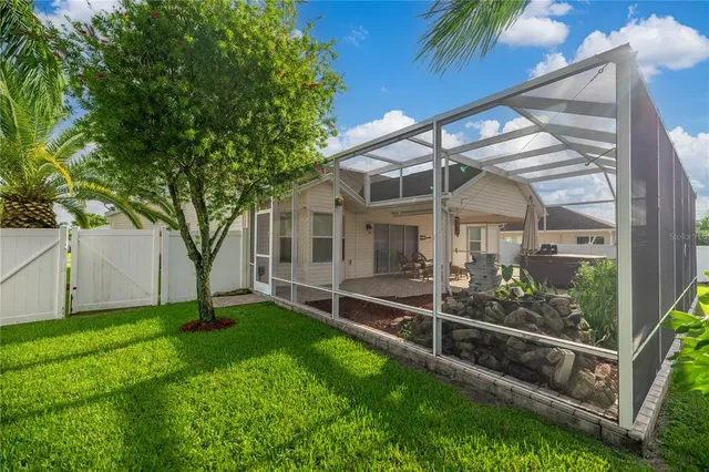 a view of a house with backyard and a tree