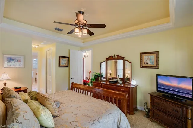 a bedroom with a large bed and a chandelier