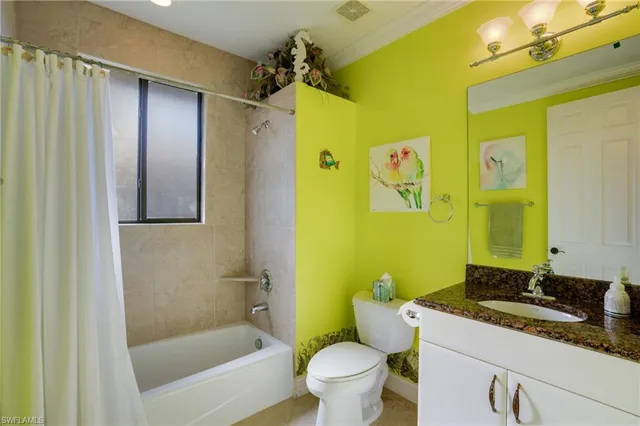 a bedroom with a bed a potted plant on dresser and a window