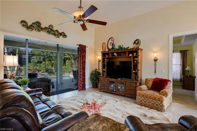 a living room with furniture a ceiling fan and a flat screen tv