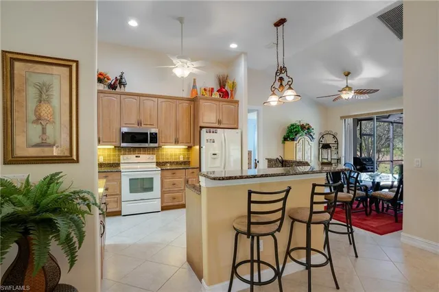 a kitchen with stainless steel appliances kitchen island granite countertop a table and chairs in it