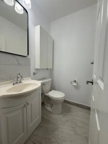 a bathroom with a toilet sink and mirror