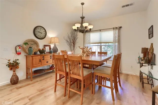 a dining room with furniture wooden floor and a chandelier