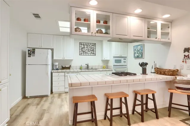 a kitchen with stainless steel appliances granite countertop a table chairs stove microwave and cabinets