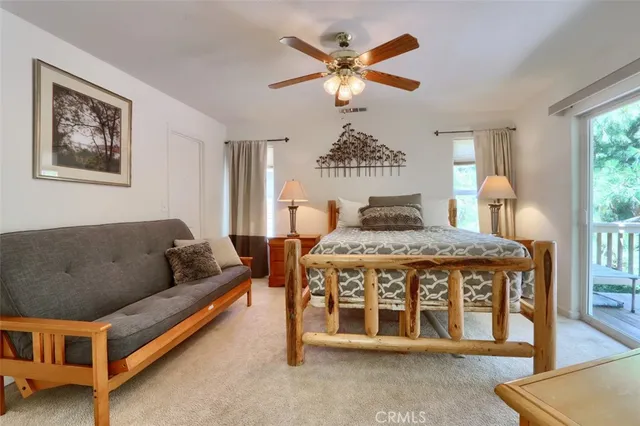 a view of a white house with a large windows and flower plants
