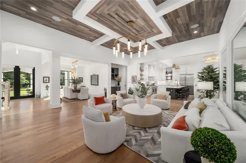 a living room with furniture a flat screen tv and a floor to ceiling window