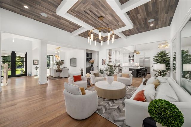 a living room with furniture a flat screen tv and a floor to ceiling window