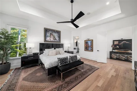 a view of a house with a small yard and floor to ceiling window and potted plants