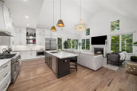 a living room with furniture a large window and a fireplace