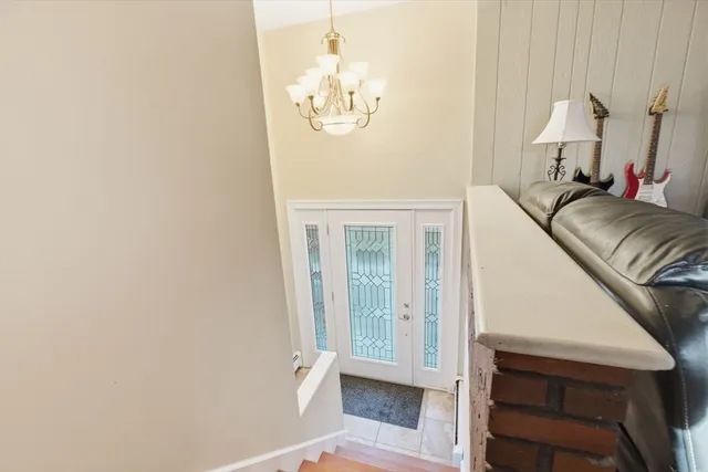 a view of a bedroom with wooden floor and a chandelier